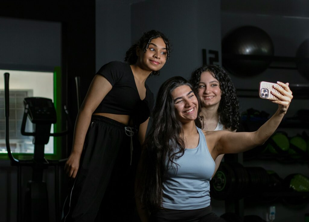 Three friends taking a selfie together at the gym